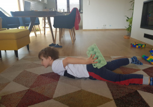 Chłopiec wykonuje ćwiczenie gimnastyczne w pozycji leżącej.